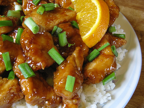 Plate of glazed chicken over rice with green onions